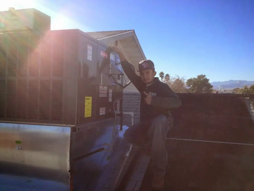 HVAC technician performing AC Tune-Up on a rooftop unit in Rhinelander