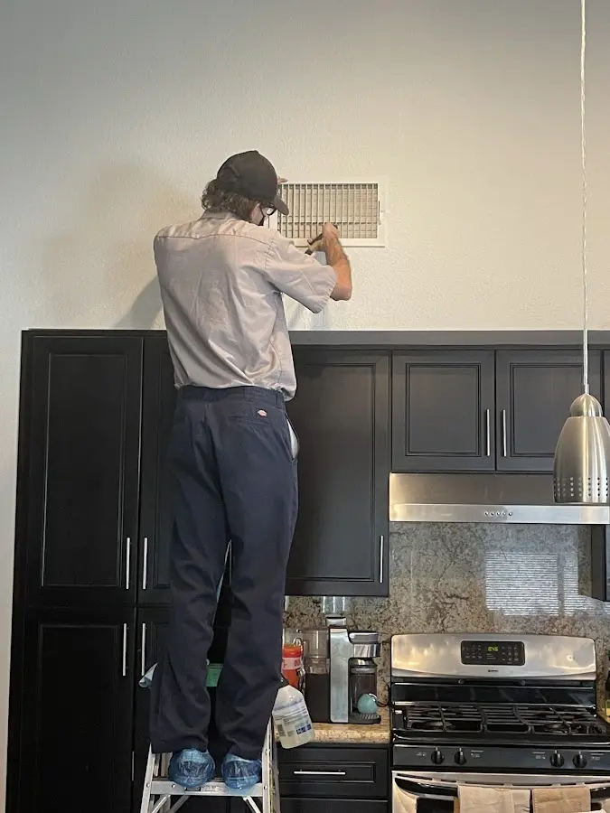 Technician inspecting an air vent during HVAC service in Rhinelander